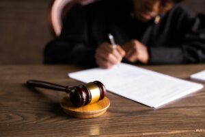 Osoba przy stole z młotkiem sędziowskim